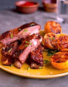 a yellow plate topped with meat and oranges