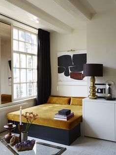 a living room with a bed, coffee table and window