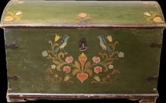 an old green painted chest with two birds on it