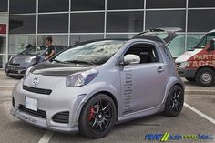 a silver smart car parked in front of a building