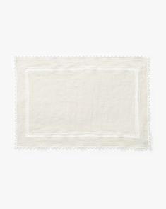 a white linen placemat with scalloped edges