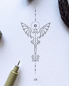 an ink drawing of a bird on paper next to a pen and some other items