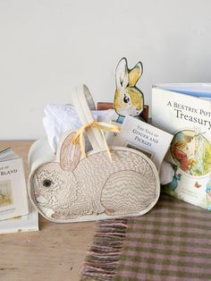 A fabric basic in the shape of a large fluffy bunny, hunched over with its ears sticking up. A light brown and pink embroidered to define the texture and facial details of the body and face. This picture has the basket holding different items such as books, flowers, and stuffed animals. Newborn Easter Basket, Coral And Tusk, Rabbit Design, Bunny Basket, Baby Chicks, Easter Egg Hunt, White Rabbit, New Mothers, Summer Picnic