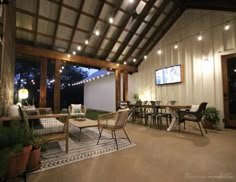 an outdoor living area with patio furniture and string lights on the ceiling is lit up at night