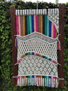 a wall hanging made out of yarn and wood