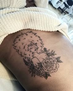 a woman's thigh with flowers and a lion tattoo on it