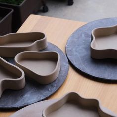 three different shaped trays sitting on top of a wooden table