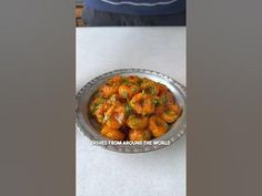 a bowl filled with food sitting on top of a table next to a person standing in front of it