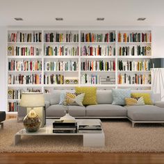 a living room filled with lots of furniture and bookshelves full of books on the wall