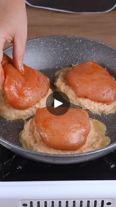 someone is cooking salmon in a skillet on the stove top and flipping them into pancakes