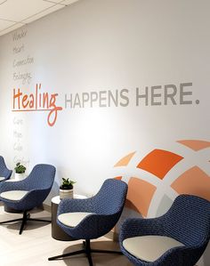 an office waiting area with chairs and a wall that says, healing happens here