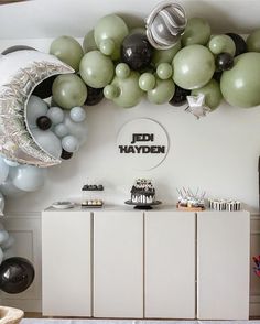 a room filled with balloons and decorations on top of a dresser next to a wall