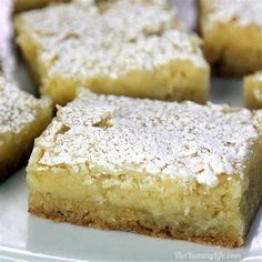 several pieces of cake on a white plate with powdered sugar toppings and spoon