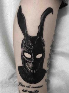 a person with a tattoo on their arm wearing a bunny mask and holding a knife