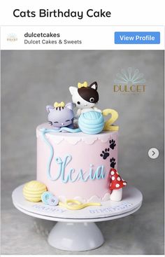 a pink cake with cats on top and the words fiesta written in blue