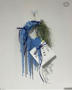 a blue scarf hanging from the side of a wall next to a book and plant