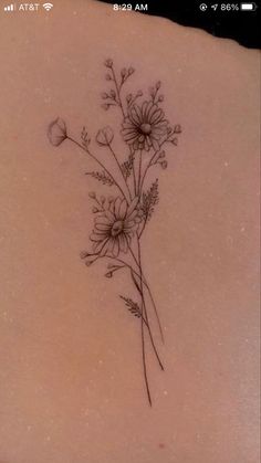 the back of a woman's stomach with flowers tattooed on her left side ribcage