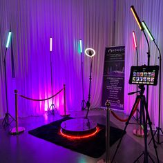 a room with purple lighting and lights on the walls, including a camera set up to record an event