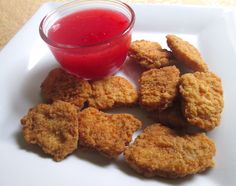 chicken nuggets with ketchup on a white plate