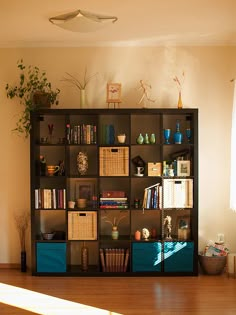 a living room filled with lots of furniture and bookshelves on top of a hard wood floor