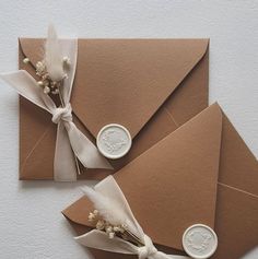 two envelopes with wax stamp and flowers tied to them