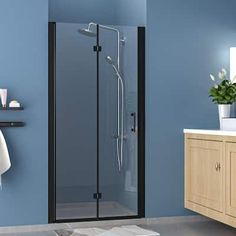 a bathroom with blue walls and white towels on the counter top, shower door is open