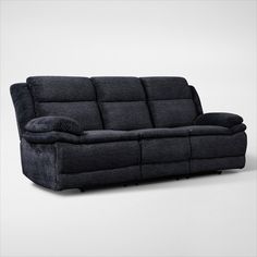 the reclining sofa has two pillows on it and is made out of black fabric