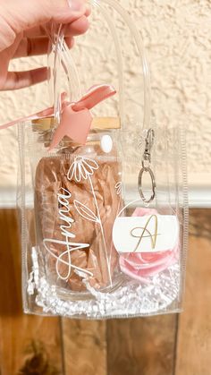 a hand holding a clear plastic bag with cookies in it and a keychain