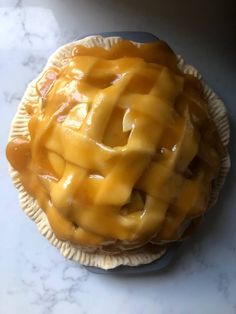 a pie sitting on top of a white counter covered in caramel cheese toppings