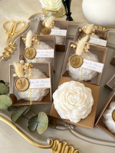 wedding favors are displayed on a tray with flowers and gold foil tags in the boxes