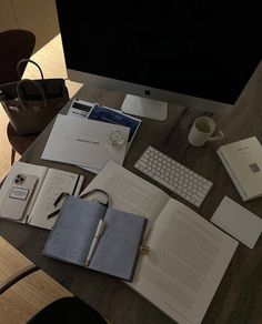 an open book sitting on top of a wooden desk next to a computer monitor and keyboard