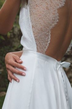 the back of a woman's wedding dress, with her hands on her hip