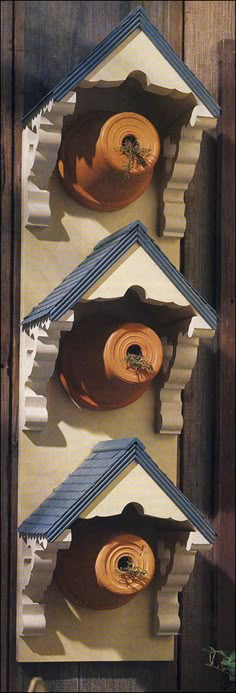 three birdhouses with blue and white roof tops