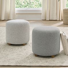 two stools sitting on top of a rug in front of a window with curtains