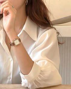 a woman sitting at a table with her hand on her chin and looking off to the side