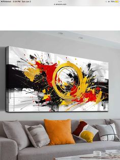 a living room with a couch and painting on the wall above it's coffee table