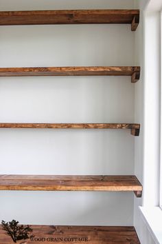 three wooden shelves in a white room