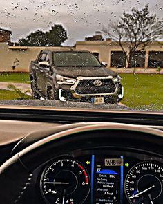 the dashboard of a car is shown in front of a house with raindrops on it