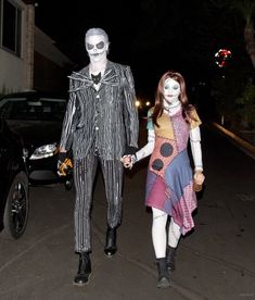 two people in costumes walking down the street