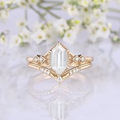 a close up view of a diamond ring with flowers in the background