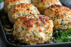 some meatballs on a black plate with parsley