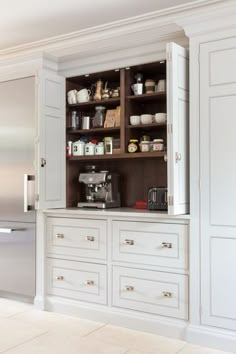 a kitchen with white cabinets and silver appliances