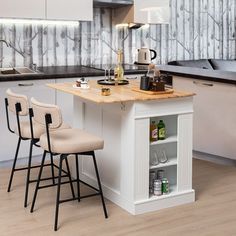 a kitchen island with two chairs next to it