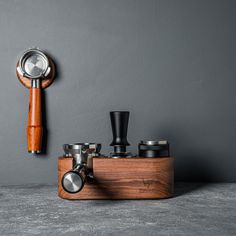 an old fashioned coffee grinder and some cups on a table next to a wall