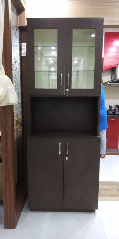 a brown cabinet with glass doors on the front and back sides, in a store