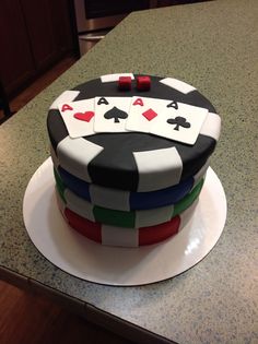 a cake decorated with playing cards on top of a kitchen counter, ready to be eaten