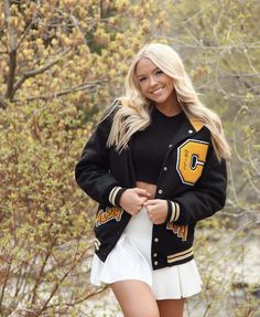 a woman wearing a black jacket and white skirt