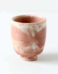 a pink and white cup sitting on top of a table