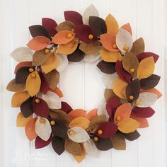 a wreath made out of felt flowers on a door