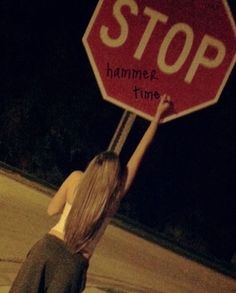 a woman holding up a stop sign with the word hammer time written on it in front of her